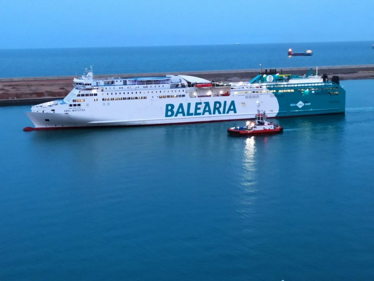 Imagen noticia: el ferry de Balearia llegando a puerto con el incendio controlado pero no extinguido - Ministerio de Transportes, Movilidad y Agenda Urbana.